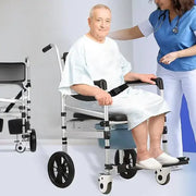Man in a wheelchair with a nurse assisting him, on a plain background