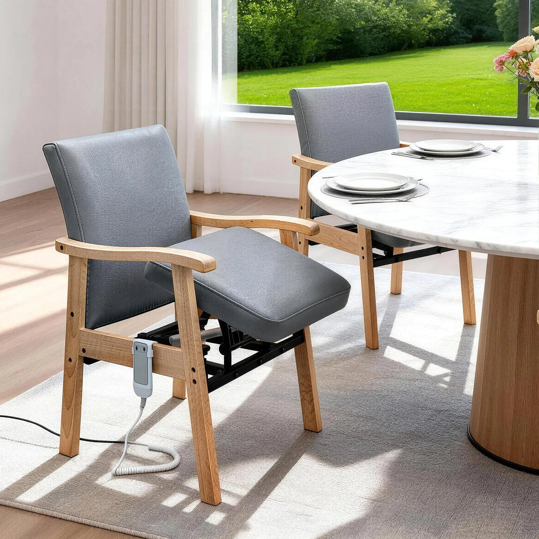 Gray power lift chair for seniors positioned beside a dining table with powered lift mechanism and remote