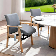 Gray power lift chair for seniors positioned beside a dining table with powered lift mechanism and remote